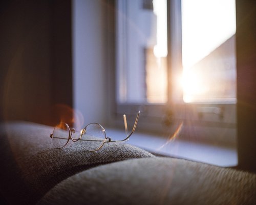 Person avoiding strong window glare while reading