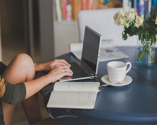 Person typing on a laptop at a bright desk