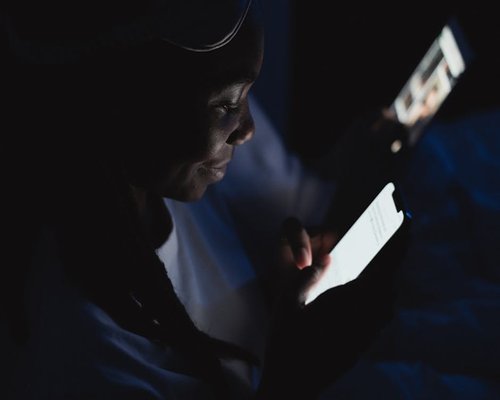 Woman using smartphone with adjusted brightness in the evening